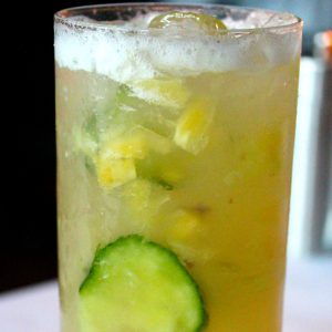 A tall cocktail with cucumber